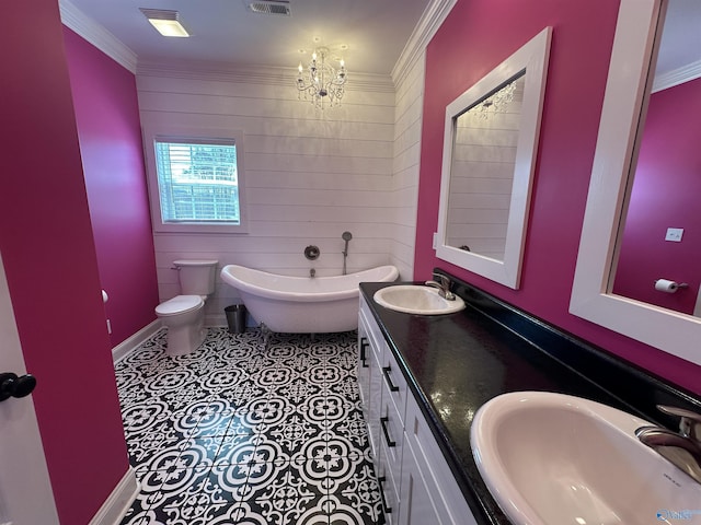 bathroom featuring a freestanding bath, a sink, crown molding, and visible vents