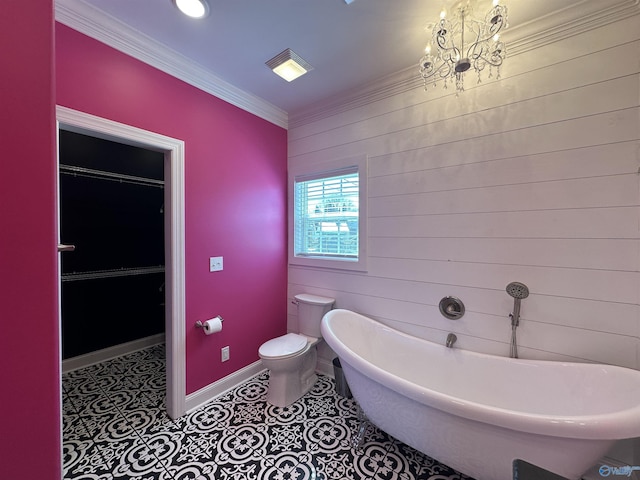 bathroom featuring tile patterned flooring, a freestanding tub, crown molding, toilet, and baseboards