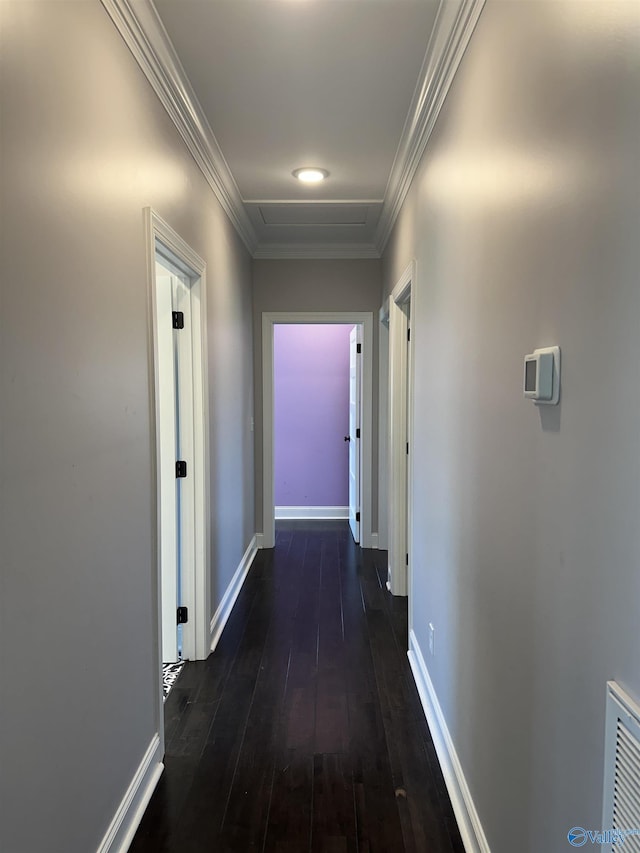 hall featuring baseboards, visible vents, dark wood-type flooring, and crown molding