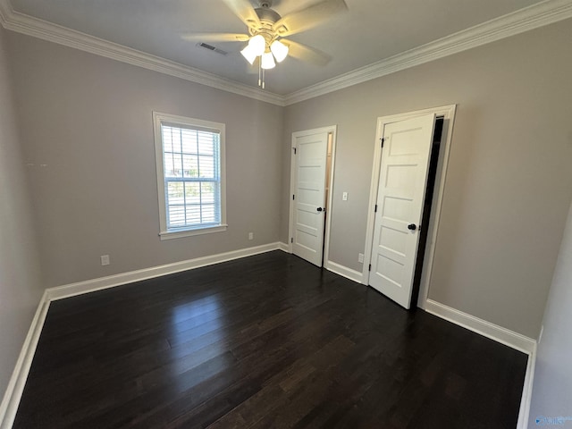 unfurnished bedroom with dark wood-style flooring, crown molding, baseboards, and visible vents