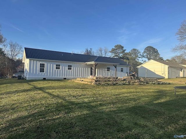 back of property featuring a lawn, metal roof, and board and batten siding