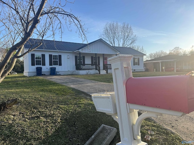view of front of property with metal roof, a front yard, and a porch