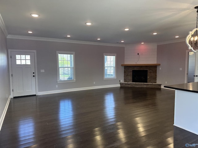 unfurnished living room with dark wood-style flooring, a chandelier, crown molding, baseboards, and recessed lighting