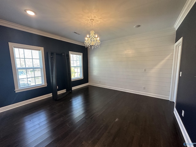 spare room with crown molding, baseboards, dark wood finished floors, visible vents, and a notable chandelier