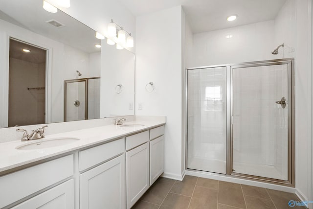 bathroom featuring vanity, a shower with shower door, and tile patterned flooring