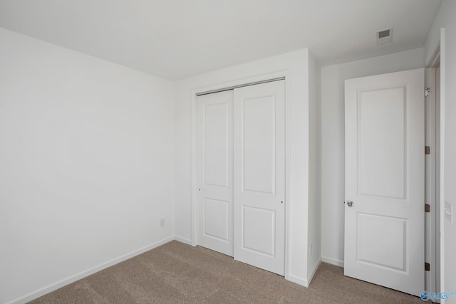 unfurnished bedroom featuring carpet and a closet