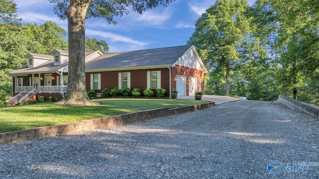 view of front of property with a garage, covered porch, and a front lawn