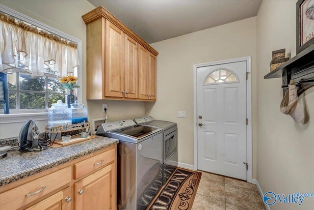 washroom featuring cabinets, light tile patterned flooring, and washing machine and clothes dryer