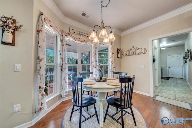 dining area with crown molding, wood-type flooring, and a healthy amount of sunlight