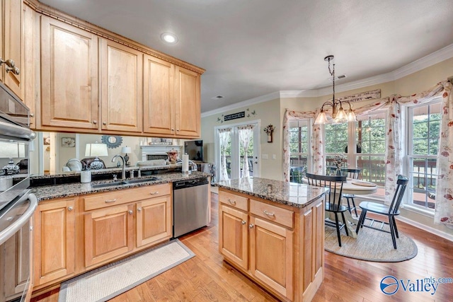 kitchen featuring a kitchen island, pendant lighting, dishwasher, sink, and dark stone counters