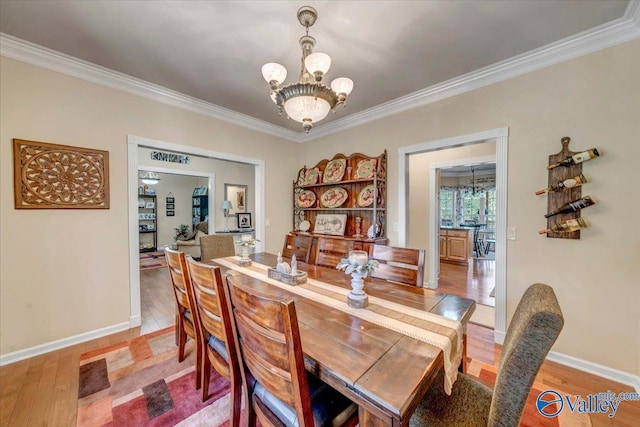 dining area featuring an inviting chandelier, crown molding, and wood-type flooring