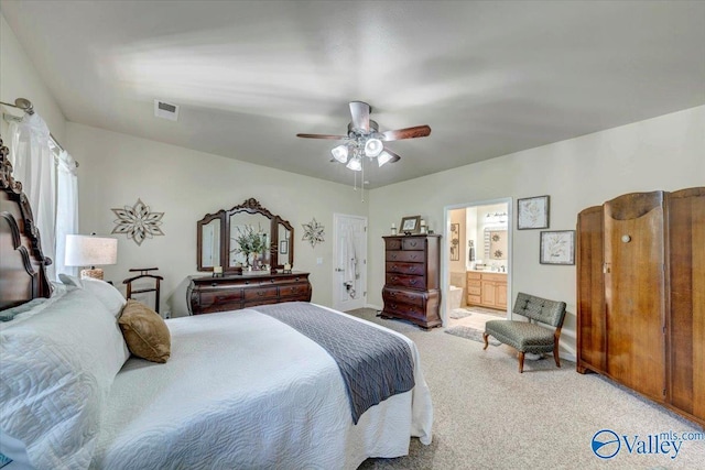 bedroom with light carpet, ensuite bath, and ceiling fan