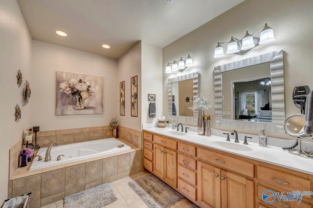 bathroom with tile patterned flooring, vanity, and tiled bath