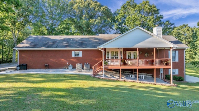 rear view of house featuring a wooden deck, ceiling fan, central AC, and a lawn