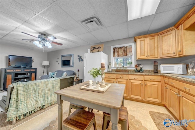 kitchen featuring ceiling fan, white appliances, light brown cabinets, and a drop ceiling