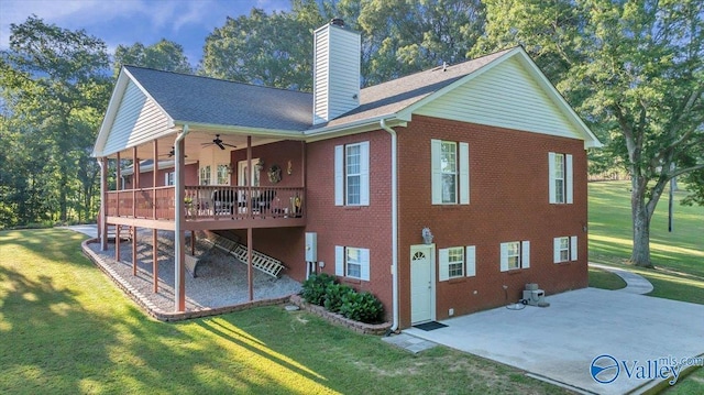 back of property with a wooden deck, a patio area, ceiling fan, and a lawn