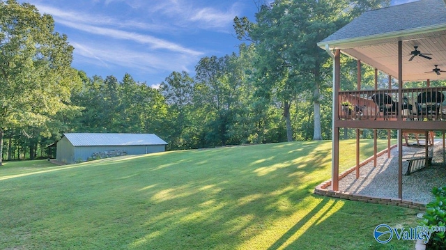 view of yard featuring ceiling fan and a deck