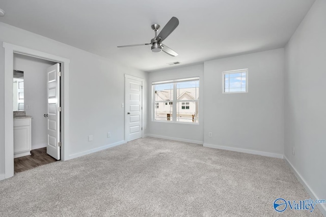 unfurnished bedroom featuring visible vents, a ceiling fan, carpet flooring, ensuite bath, and baseboards