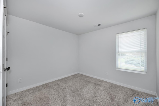 carpeted empty room with visible vents and baseboards