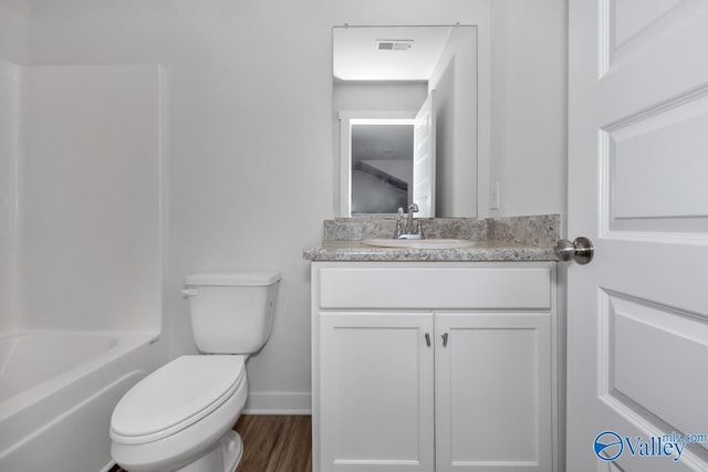 bathroom with toilet, wood finished floors, vanity, visible vents, and baseboards