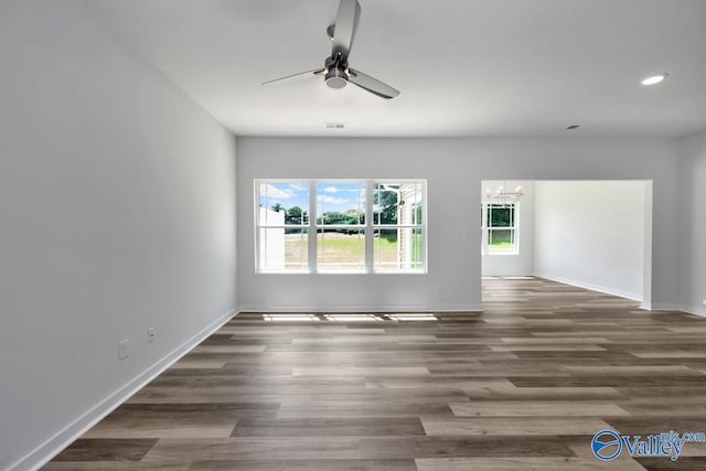 unfurnished room with recessed lighting, baseboards, wood finished floors, and ceiling fan with notable chandelier