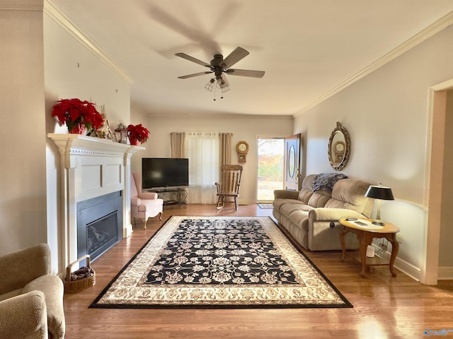 living room with crown molding, ceiling fan, and hardwood / wood-style flooring