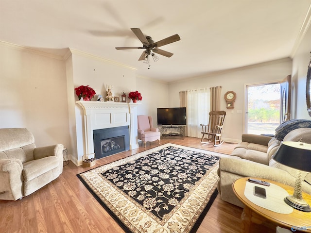 living room featuring ceiling fan, ornamental molding, and hardwood / wood-style flooring