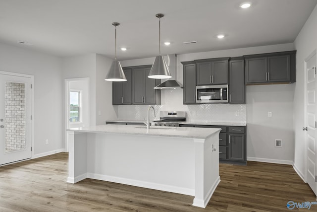 269 Shubert Dr, Hazel Green, AL 35750 - kitchen featuring stainless steel appliances, a sink, wall chimney range hood, backsplash, and an island with sink
