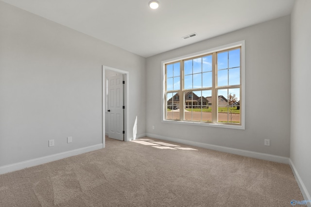 spare room with baseboards, visible vents, and carpet flooring