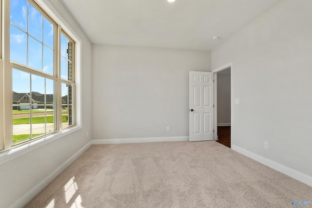 unfurnished room with carpet floors and baseboards