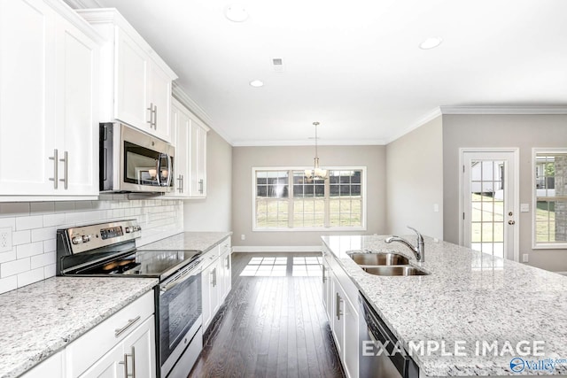 kitchen with appliances with stainless steel finishes, light stone counters, white cabinets, dark hardwood / wood-style flooring, and sink