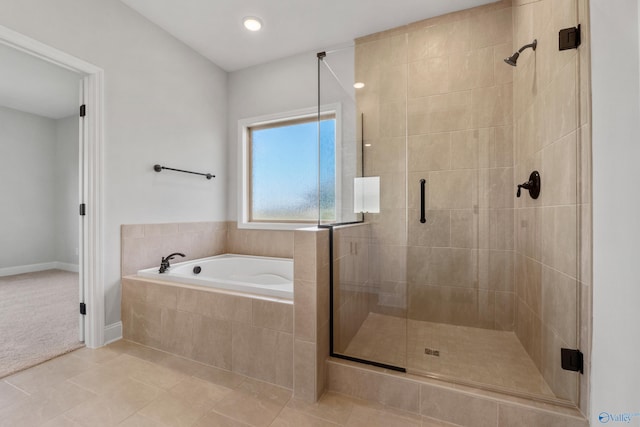 bathroom featuring a garden tub, a shower stall, and tile patterned flooring