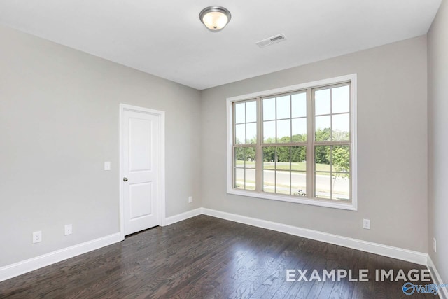 empty room with dark hardwood / wood-style flooring