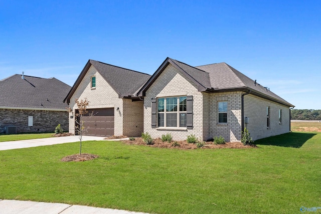 french country inspired facade featuring a garage, brick siding, a shingled roof, driveway, and a front lawn