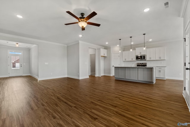 unfurnished living room with baseboards, visible vents, ceiling fan, dark wood-style flooring, and crown molding