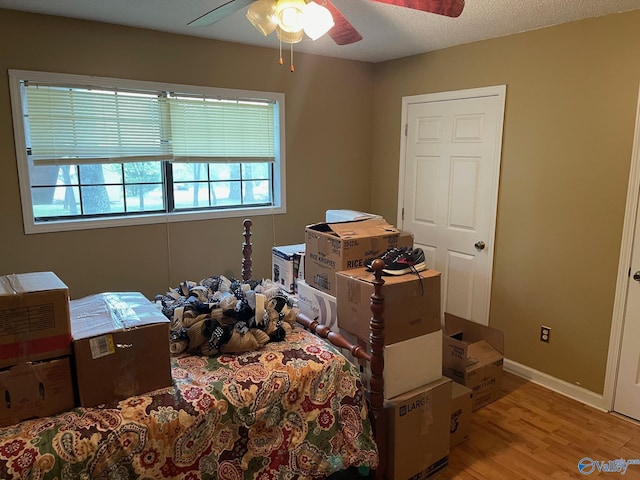 bedroom featuring baseboards, a ceiling fan, and wood finished floors