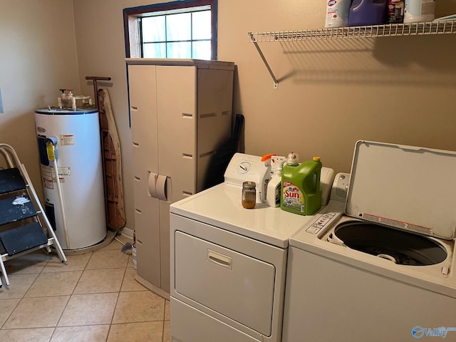 laundry room featuring washer and dryer, gas water heater, laundry area, and light tile patterned floors