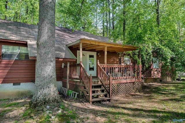 view of front facade with roof with shingles, crawl space, and covered porch