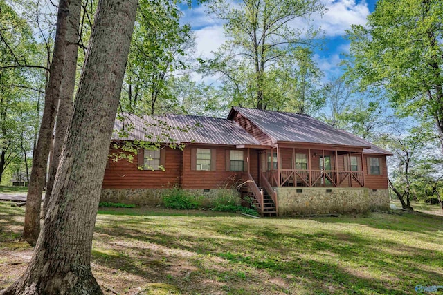 view of front of property with crawl space, a front lawn, stairs, and metal roof