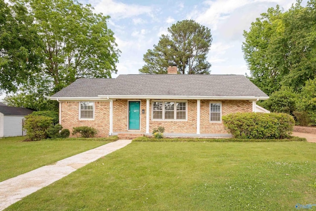 view of front of home featuring brick siding, a front yard, a chimney, and a shingled roof