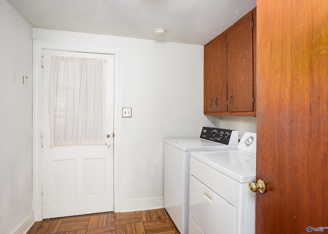 laundry room featuring separate washer and dryer, cabinet space, and baseboards