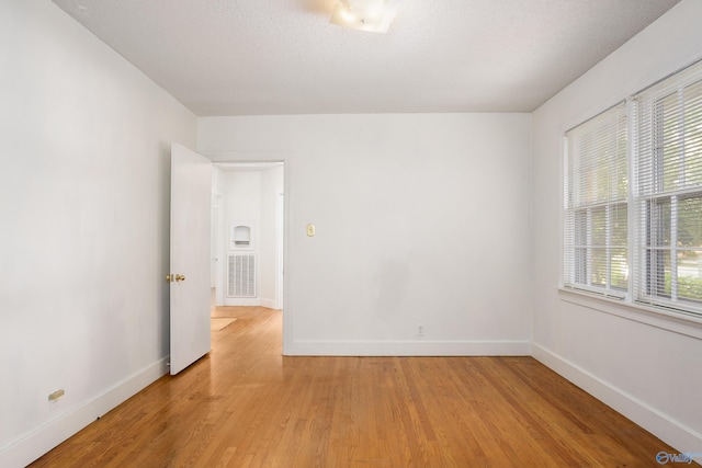unfurnished room featuring baseboards and light wood-style flooring