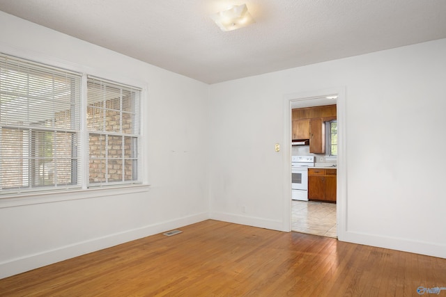 unfurnished room with baseboards and light wood-style flooring