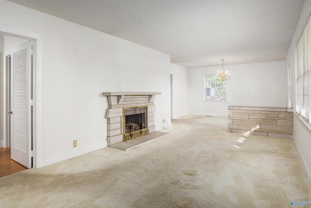 unfurnished living room with carpet, a chandelier, a fireplace, and baseboards