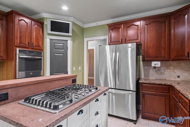 kitchen featuring crown molding, white cabinetry, stainless steel appliances, and decorative backsplash