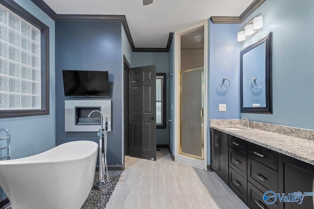 bathroom with ornamental molding, independent shower and bath, and vanity