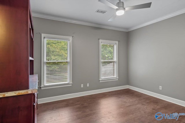 spare room with dark hardwood / wood-style flooring, plenty of natural light, ornamental molding, and ceiling fan