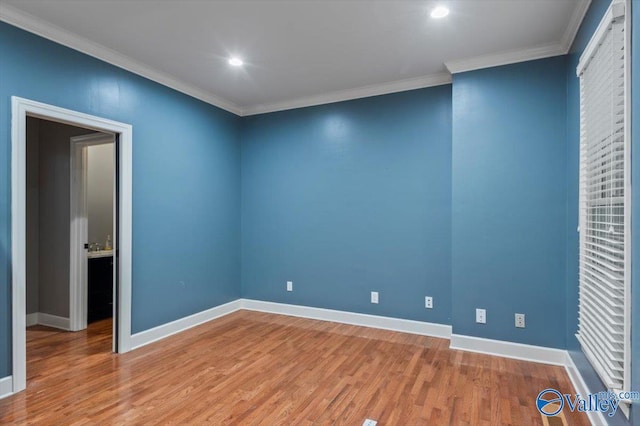 empty room featuring ornamental molding and wood-type flooring