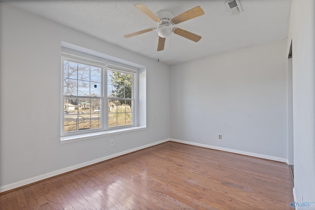 empty room featuring ceiling fan, hardwood / wood-style floors, and a textured ceiling