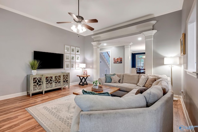 living room with ornate columns, wood finished floors, a ceiling fan, and crown molding